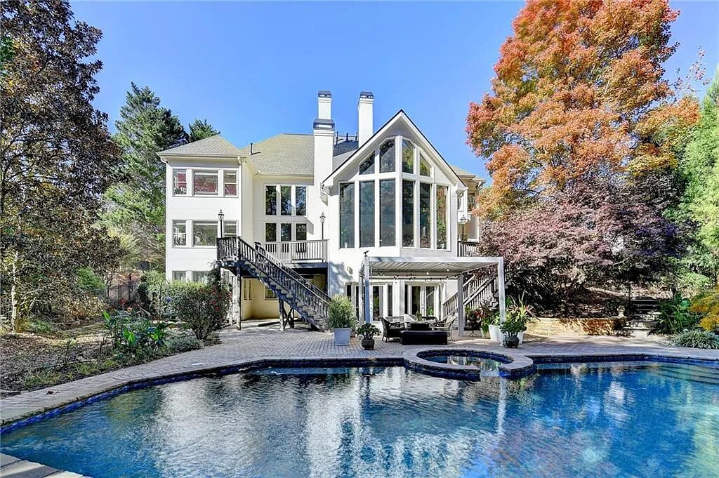 Back of the home with pool and spa