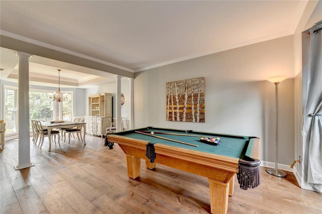 Living room with a pool table, opening to the dining room