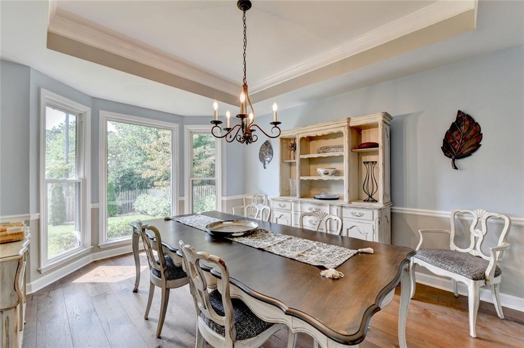 Formal dining room with a bay window and tray ceiling