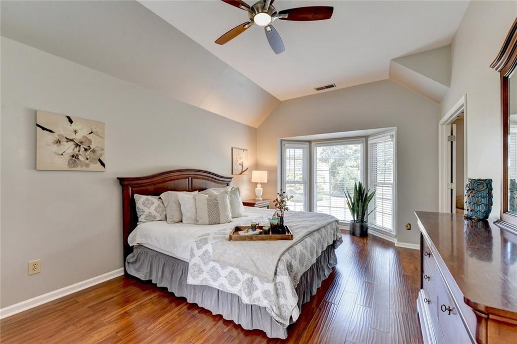 Bedroom with a vaulted ceiling and bay window